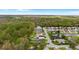 Aerial view of a community featuring homes with pools bordered by lush green trees and manicured lawns at 1526 Country Chase St, Lakeland, FL 33810