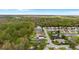 Aerial view of a community featuring homes with pools bordered by lush green trees and manicured lawns at 1526 Country Chase St, Lakeland, FL 33810