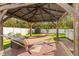 Backyard gazebo featuring brick floors and a hammock with green trees and a privacy fence in the background at 1526 Country Chase St, Lakeland, FL 33810