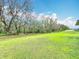 Expansive backyard features lush greenery, mature trees, and plenty of space for outdoor activities at 153 Heritage Park Ln, Mulberry, FL 33860