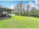 The well-maintained backyard features a large lawn with trees and provides space for outdoor enjoyment at 153 Heritage Park Ln, Mulberry, FL 33860
