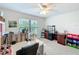 Bright bedroom provides a ceiling fan and neutral color palette offering a versatile space for any hobbyist at 153 Heritage Park Ln, Mulberry, FL 33860