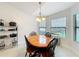 Sunlit dining area with a wooden table, seating for four, and views of the lush backyard at 153 Heritage Park Ln, Mulberry, FL 33860