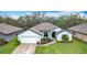 Charming single-story home featuring a manicured lawn and attached two-car garage in a friendly neighborhood at 153 Heritage Park Ln, Mulberry, FL 33860