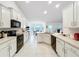 Bright kitchen boasts white cabinets, tile floors, modern appliances, and a spacious layout at 153 Heritage Park Ln, Mulberry, FL 33860