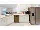Bright kitchen featuring white cabinetry, stainless steel appliances, and views into the living room at 153 Heritage Park Ln, Mulberry, FL 33860