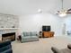Cozy living room featuring a stone fireplace, plush seating, and a large screen television at 153 Heritage Park Ln, Mulberry, FL 33860
