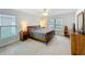 Spacious main bedroom with neutral carpet, ceiling fan, and large windows providing natural light at 153 Heritage Park Ln, Mulberry, FL 33860