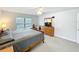 Inviting main bedroom featuring wood furniture, plush carpet, and a comfortable king-sized bed at 153 Heritage Park Ln, Mulberry, FL 33860