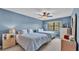 Serene bedroom with two beds, soft blue walls, ceiling fan, and natural light at 159 Coventry Cir, Haines City, FL 33844