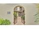 A gated entryway with an arched opening leads to a charming courtyard and front door at 159 Coventry Cir, Haines City, FL 33844