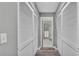 Hallway featuring hardwood floors and two closet doors looking into a shower with white and gray accent tiles at 159 Coventry Cir, Haines City, FL 33844