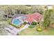 Beautiful home exterior with a screened-in pool, red tile roof, mature landscaping, and a long private driveway at 159 Coventry Cir, Haines City, FL 33844