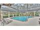 Relaxing screened-in pool area featuring a refreshing pool, outdoor seating, and lush landscaping at 159 Coventry Cir, Haines City, FL 33844