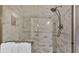 Close-up of the shower featuring beautiful white and gray accent tiles, a shower head, and a glass door at 159 Coventry Cir, Haines City, FL 33844
