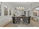 Dining room showcases a modern chandelier, large windows and flows into the kitchen at 168 Hampton Loop, Davenport, FL 33837