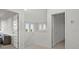 Hallway with neutral walls and light flooring, showcasing multiple doorways and natural light from transom windows at 168 Hampton Loop, Davenport, FL 33837