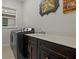 Laundry room with sleek cabinets, quartz counters, modern washer and dryer, and a window at 168 Hampton Loop, Davenport, FL 33837