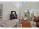 Open living room features tall windows, stylish furniture, and a staircase to the upper level at 168 Hampton Loop, Davenport, FL 33837