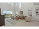 Bright living room featuring tall windows, elegant furniture, and neutral decor with outdoor views at 168 Hampton Loop, Davenport, FL 33837
