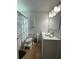 Bright bathroom featuring a double sink vanity and a gray marble-patterned shower curtain at 1771 Bayview Dr, Lakeland, FL 33805