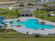 Aerial view of a stunning community pool with lounge chairs and shade, surrounded by lush landscaping at 1946 Pond Pine Ct, Haines City, FL 33844