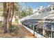 An enclosed sunroom, with surrounding lawn and mature landscaping, adds charm to this home's backyard at 21 Townhill Dr, Eustis, FL 32726
