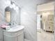 Elegant white bathroom with a marble tile wall, oval mirror, and a vanity with stylish curved accents at 21 Townhill Dr, Eustis, FL 32726