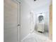 Bright bathroom with marble floors, marble accents, white vanity, round mirror, and two paneled doors at 21 Townhill Dr, Eustis, FL 32726