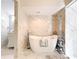 Well-lit bathroom with marble walls, soaking tub, marble flooring, and white floating sink at 21 Townhill Dr, Eustis, FL 32726