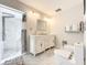 Spacious bathroom featuring double vanity, marble tile, large mirror, and a shower with multi-head system at 21 Townhill Dr, Eustis, FL 32726