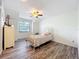 Sunlit bedroom with light walls and wooden-look vinyl flooring at 21 Townhill Dr, Eustis, FL 32726