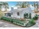 Charming one-story home with white exterior, manicured lawn, and lush landscaping at 21 Townhill Dr, Eustis, FL 32726