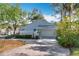 Charming home with a well-manicured front yard, mature trees, and a neutral color scheme at 21 Townhill Dr, Eustis, FL 32726