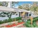 Charming one-story home with white exterior, front porch, mature trees, and lush landscaping at 21 Townhill Dr, Eustis, FL 32726