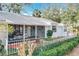 Charming home with landscaped front yard, screened porch, and mature trees at 21 Townhill Dr, Eustis, FL 32726