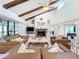 Spacious living room featuring vaulted ceilings, exposed wood beams, and a stone fireplace at 21 Townhill Dr, Eustis, FL 32726