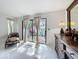 Sunlit main bedroom featuring tile floors, access to a private backyard, and elegant furnishings at 21 Townhill Dr, Eustis, FL 32726