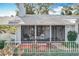 Charming screened porch with comfortable seating and a beautiful view of the landscaped front yard at 21 Townhill Dr, Eustis, FL 32726