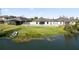 Back exterior of a home overlooking a serene lake, framed by a white picket fence at 2443 Torrens Dr, Lakeland, FL 33805
