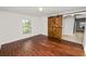 Spacious bedroom with wood-look floors and a rustic sliding barn door at 2443 Torrens Dr, Lakeland, FL 33805
