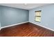 Comfortable bedroom featuring wood-look flooring, window with blinds, and a soothing wall color at 2443 Torrens Dr, Lakeland, FL 33805