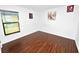 Inviting bedroom featuring wood-look flooring, white walls, and a window for natural light at 2443 Torrens Dr, Lakeland, FL 33805