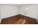 Bright, empty bedroom featuring a light fixture and a window with wood-look blinds at 2443 Torrens Dr, Lakeland, FL 33805