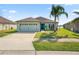 Charming single-story home with well-maintained lawn, attached two-car garage and lake view at 2443 Torrens Dr, Lakeland, FL 33805