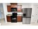 Efficient kitchen with granite counters, stainless steel refrigerator, black oven, and ample wood cabinets at 2443 Torrens Dr, Lakeland, FL 33805