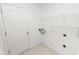 A simple laundry room with a door, white walls, tile floors, and wire shelving at 2443 Torrens Dr, Lakeland, FL 33805