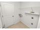 A laundry room with washer hookups, a door, tiled flooring, and shelving at 2443 Torrens Dr, Lakeland, FL 33805