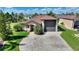Beautiful single-story home featuring a paver driveway, front yard landscaping and an attached garage at 246 Laynewade Rd, Polk City, FL 33868