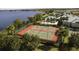 Aerial view of tennis courts, pool and community, nestled by the lake, offers a resort-like experience for residents at 2820 Attwater Loop, Winter Haven, FL 33884